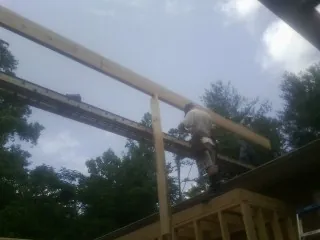 Carpenter setting a ridge beam over a new addition frame — Ice Dam Removal by Roofing Brothers in Willernie