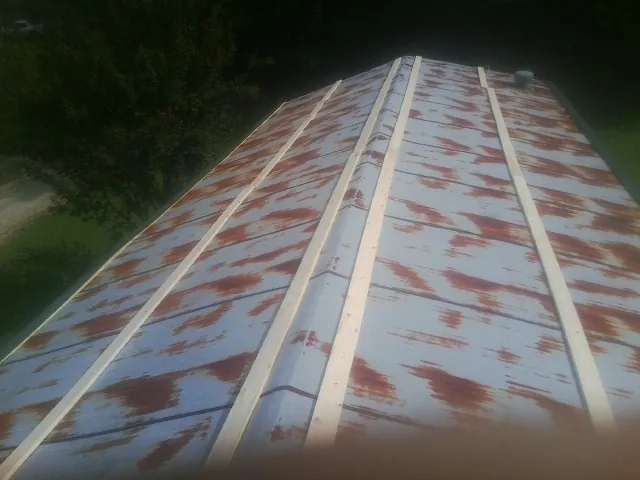 Rusted metal roof panels with new wood purlins before replacement — Storm Damage Roof Repair in Willernie by Roofing Brothers