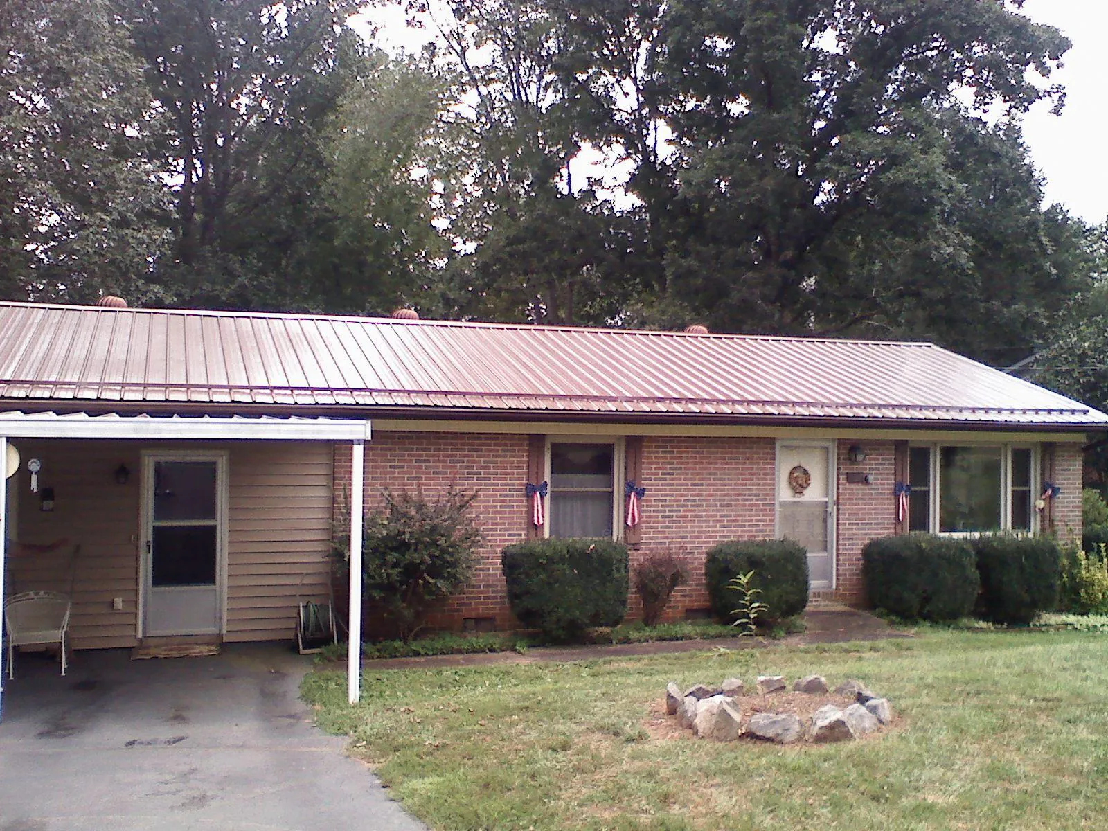 Bronze metal roof and carport on a brick ranch home — Roof Repair work by our crew in Willernie